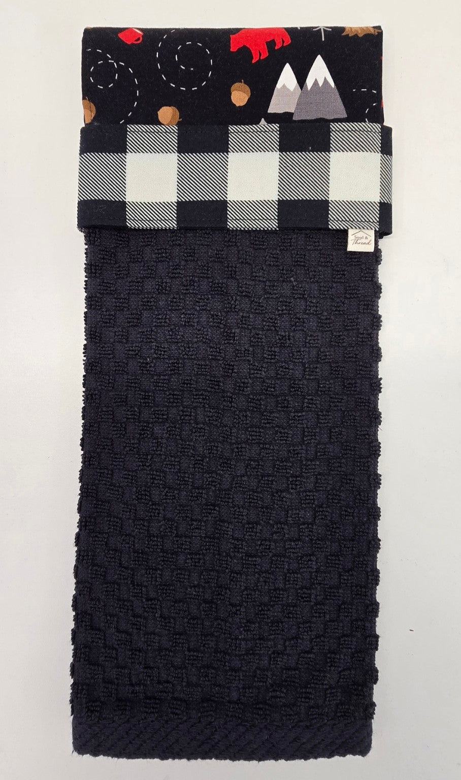 Black hanging towel with black and white buffalo plaid band and Cabin Trail topper