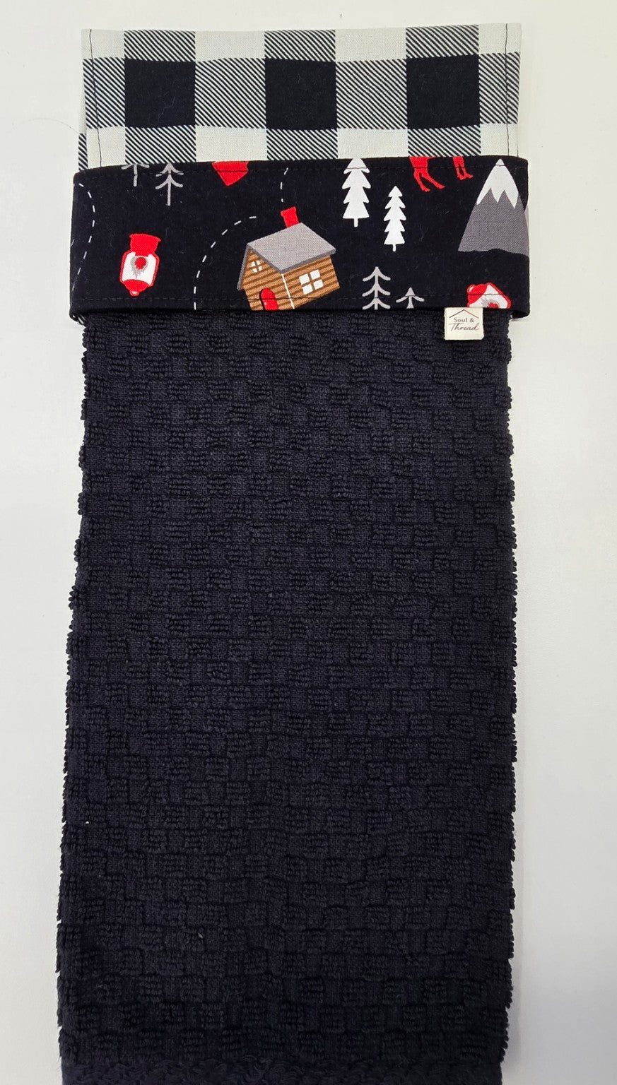 Black hanging towel with Cabin Trail woodland print band and buffalo plaid topper