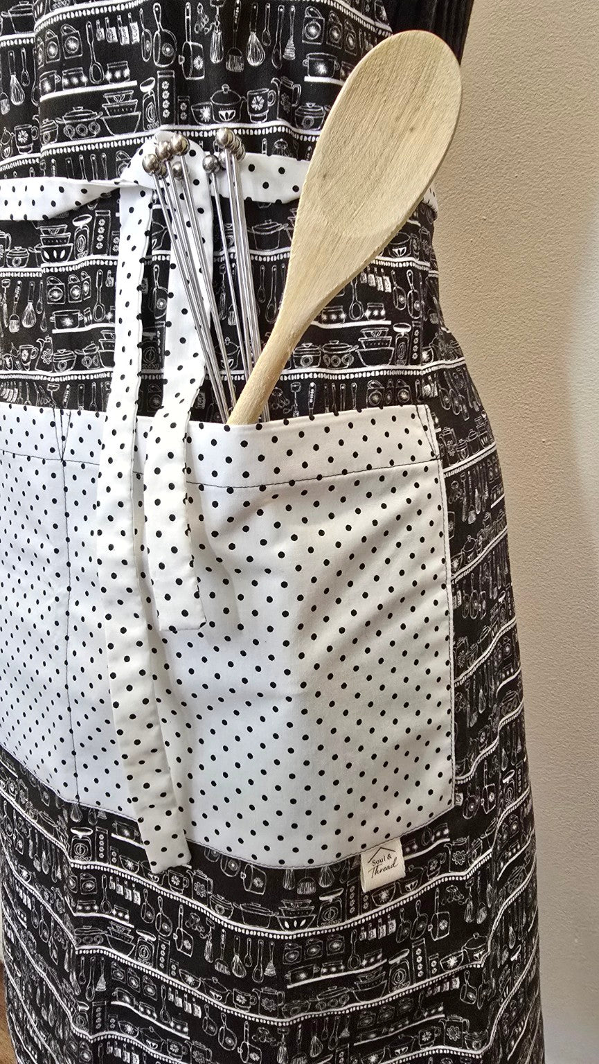 Close-up of white polka dot pocket and utensils on Classic Kitchen apron