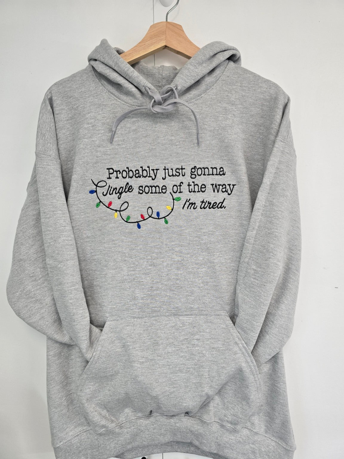 Grey Jingle Some of the Way embroidered Christmas hoodie on hanger