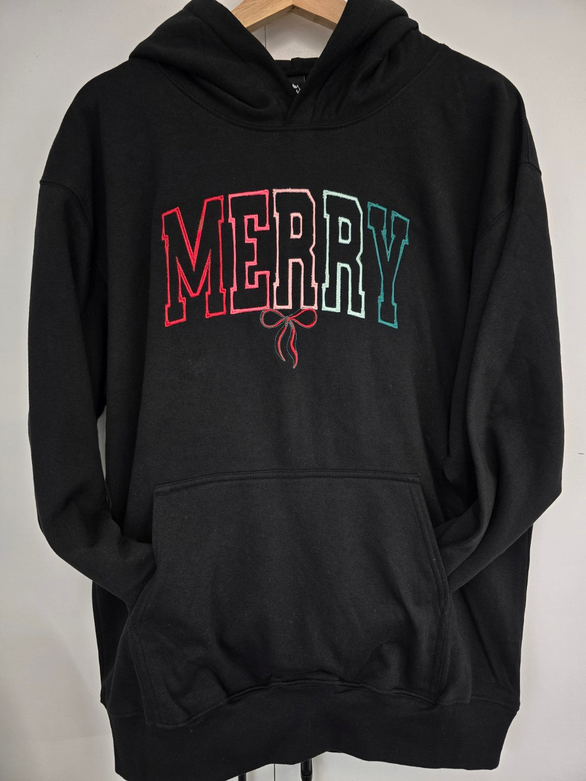 Black Merry embroidered Christmas hoodie on hanger